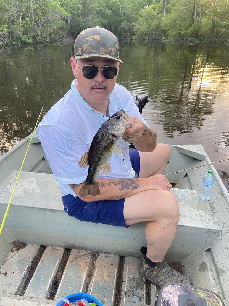 Man Holding Largemouth Bass in a boat